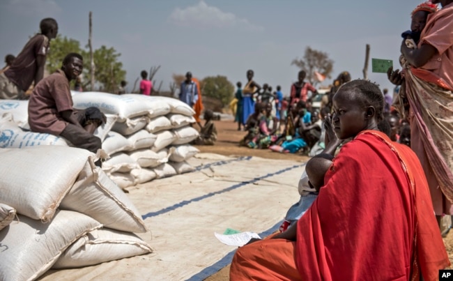 People wait to receive food at a World Vision food distribution site in Malualkuel in the Northern Bahr el Ghazal region of South Sudan, April 5, 2017.
