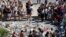 People form a circle around flowers placed on the road in tribute to victims of the truck attack along the Promenade des Anglais on Bastille Day that killed scores and injured as many in Nice, France, July 17, 2016. 