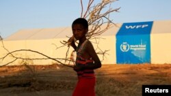 FILE - A refugee walks past a World Food Program tent at Um-Rakoba camp, in al-Qadarif state, Sudan, Nov. 23, 2020. Gunmen looted a WFP warehouse in the country's North Darfur state, officials said Wednesday.