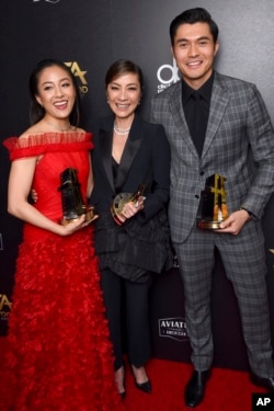 FILE - From left, Constance Wu, Michelle Yeoh and Henry Golding, winners of the Hollywood breakout ensemble award for "Crazy Rich Asians," are pictured in the press room at the Hollywood Film Awards, Nov. 4, 2018, at the Beverly Hilton Hotel in Beverly Hi