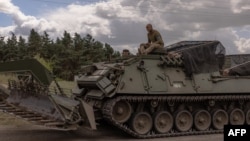 Des militaires ukrainiens sur un véhicule blindé dans la région de Sumy, près de la frontière avec la Russie, le 13 août 2024. Roman PILIPEY / AFP