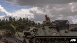 Des militaires ukrainiens conduisent un véhicule militaire blindé dans la région de Soumy, près de la frontière avec la Russie, le 13 août 2024. (Photo de Roman PILIPEY / AFP)