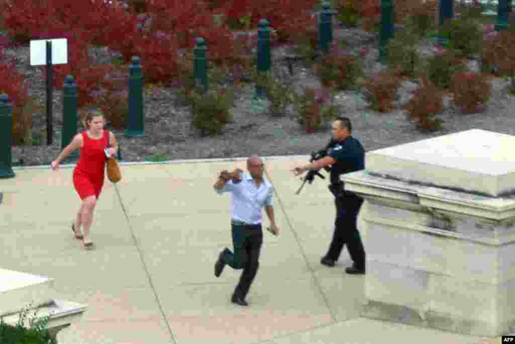 People run for cover as police converge to the site of a shooting on Capitol Hill in Washington, Oct. 3, 2013.