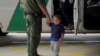 Un agente de la patrulla fronteriza de EE. UU. toma de la mano a un niño que ha entrado irregularmente en el país, en este caso, acompañado de su madre, en busca de asilo, el 15 de marzo de 2021.