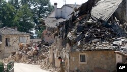 在意大利中部山地农业地区的灾区，一位军人走过瓦砾（2016年8月27日）