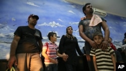 Asylum seekers rescued from heavy seas off Java, wait inside a temporary detention room upon arrival at a local marine police station in Surabaya, East Java, Indonesia, July 29, 2012.
