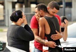 Friends and family members embrace outside the Orlando Police Headquarters during the investigation of a shooting at the Pulse night club in Orlando, Florida, June 12, 2016.