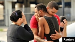 Friends and family members embrace outside the Orlando Police Headquarters during the investigation of a shooting at the Pulse night club in Orlando, Florida, June 12, 2016. REUTERS/Steve Nesius