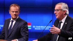 FILE - European Council President Donald Tusk, left, and European Commission President Jean-Claude Juncker participate in a news conference at the end of an EU-South Africa summit at the Europa building in Brussels on Thursday, Nov. 15, 2018. 