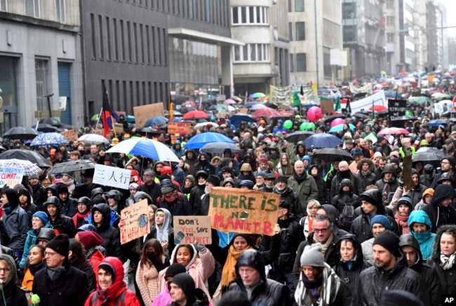 FILE - Protesters hold banners as they march during a "Rise for the Climate" demonstration in Brussels, Belgium, Jan. 27, 2019.