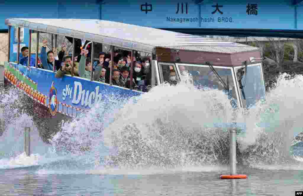 An amphibious bus &#39;Sky Duck&#39; goes into the water during its trial run in Tokyo, Japan.
