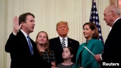 U.S. Supreme Court Associate Justice Brett Kavanaugh participates in his ceremonial public swearing-in with retired Justice Anthony Kennedy as U.S. President Donald Trump and Kavanaugh's wife, Ashley, and daughters Liza and Margaret look on in the East Room.
