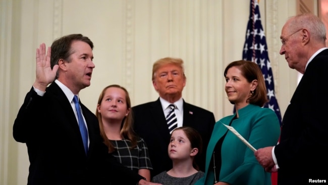 U.S. Supreme Court Associate Justice Brett Kavanaugh participates in his ceremonial public swearing-in with retired Justice Anthony Kennedy as U.S. President Donald Trump and Kavanaugh's wife, Ashley, and daughters Liza and Margaret look on in the East Room.