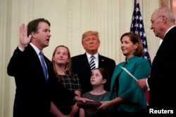 U.S. Supreme Court Associate Justice Brett Kavanaugh participates in his ceremonial public swearing-in with retired Justice Anthony Kennedy as U.S. President Donald Trump and Kavanaugh's wife, Ashley, and daughters Liza and Margaret look on in the East Room of the White House.