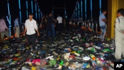 Cambodians walk through piles of shoes on a newly-built bridge where the worst stampede in their country's modern history happened, killing at least 345 people on Monday, November 22, 2010.