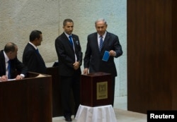 Israel's Prime Minister Benjamin Netanyahu, right, casts his ballot for the presidential election at the Knesset, Israel's parliament, in Jerusalem, June 10, 2014.