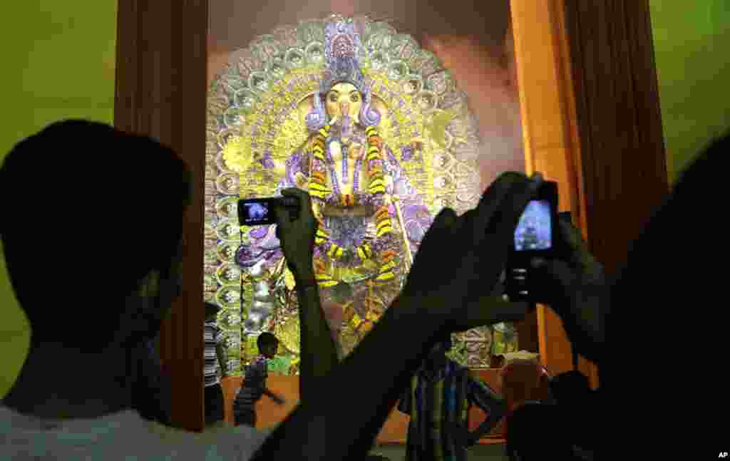 Tín đồ Hindu chụp ảnh thần tượng đầu voi Thần Ganesha tại một đền thờ trong ngày đầu tiên của lễ hội Ganesha Chaturthi ở Kolkata, Ấn Độ.