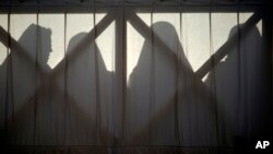 FILE - Nuns are silhouetted in St. Peter's Square at the Vatican, April 1, 2018. The Vatican is facing a dilemma after nearly all the nuns in a tiny French religious order threatened to renounce their vows rather than accept the removal of their superior.