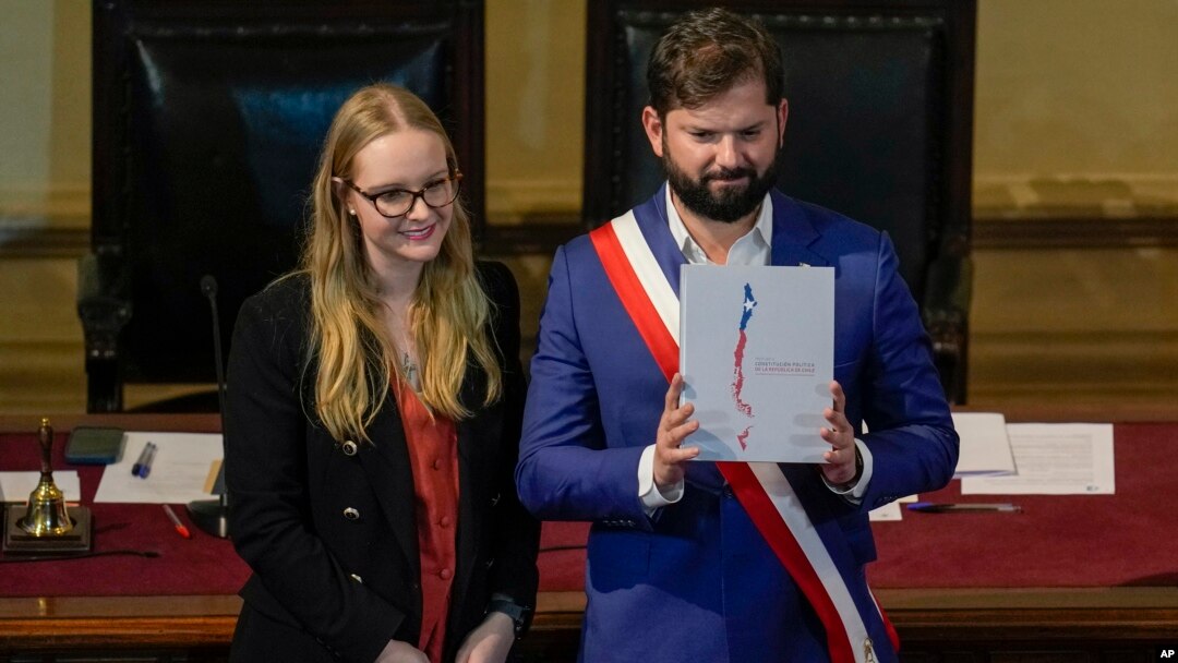 El presidente chileno, Gabriel Boric, sostiene el borrador final de la nueva Constitución, presentada por la presidenta del Consejo Constitucional, Breatriz Hevia, ante el consejo en el antiguo edificio del Congreso Nacional en Santiago, Chile, el 7 de noviembre de 2023.