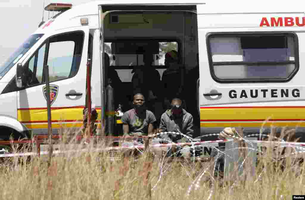 Terduga penambang-penambang liar menunggu dirawat setelah muncul dari tambang emas tua di Benoni, sebelah timur Johannesburg, Afrika Selatan (17/2). (Reuters/Mike Hutchings)
