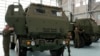 FILE - Polish soldiers look at a vehicle carrying one of the U.S.-made HIMARS rocket launchers, at an air base in Warsaw, Poland, on Monday, 15 May 2023. U.S. officials said that a military aid package for Ukraine would include munitions for HIMARS.
