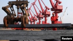 A worker loads steel bars for export at a port in Lianyungang, Jiangsu province Jun. 4, 2013.