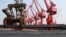 A worker loads steel bars for export at a port in Lianyungang, Jiangsu province June 4, 2013.