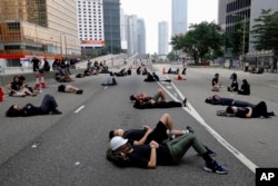 Protesters who camped out overnight take a rest along a main road near the Legislative Council after continuing protest against the unpopular extradition bill in Hong Kong, June 17, 2019.