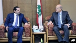 Lebanon's PM-designate Najib Mikati (R) meets with caretaker PM Saad Hariri (L) at the Parliament during consultations to form a new cabinet, Beirut, Jan 27 2011