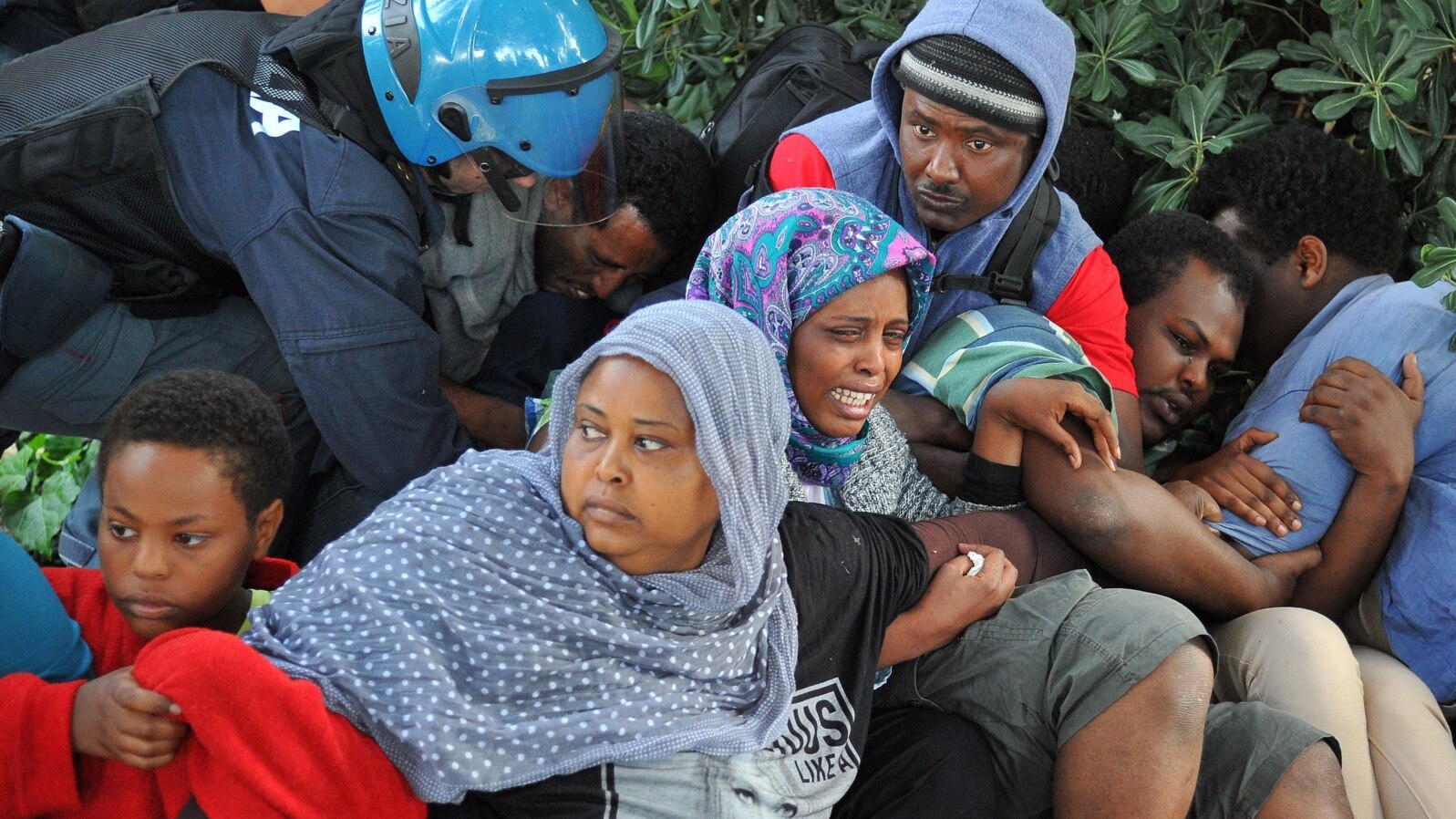 Police in Ventimiglia, Italy drag Eritrean and Sudanese refugees from encampments near the French border last June. Paris officials refused to let them cross into France.
