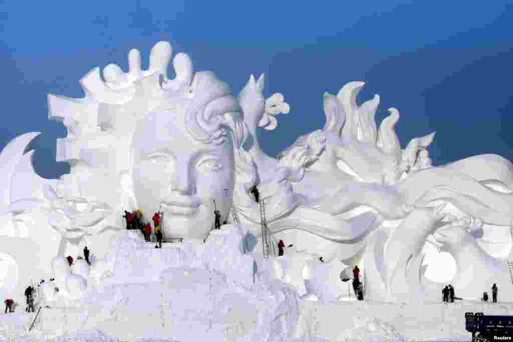 Artists work on snow sculptures at an exhibition in Harbin, Heilongjiang province, China.