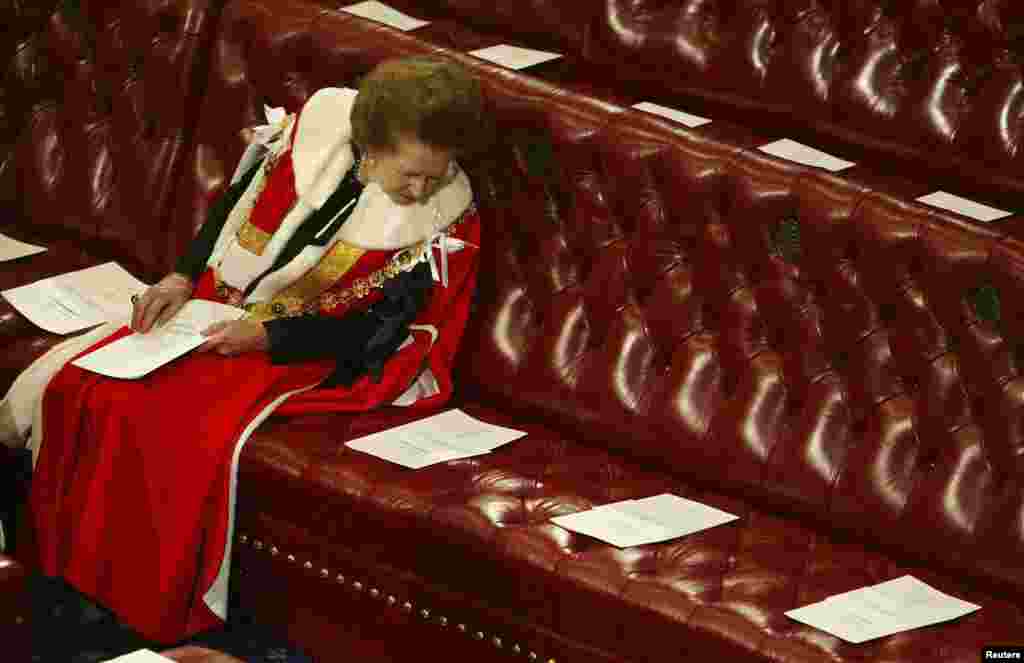 Britain&#39;s Baroness Thatcher read the order of service surrounded by empty seats as she waited for Queen Elizabeth to deliver her speech at the State Opening of Parliament in the House of Lords, Nov. 13, 2002. 