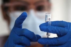 FILE - A nurse draws from a vial of Johnson & Johnson coronavirus vaccine, in Los Angeles, California, March 25, 2021.