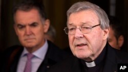 Kardinal Australia, George Pell (kanan) membacakan pernyataan tertulis kepada wartawan di Roma, Kamis (3/3).