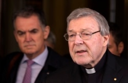 FILE - Australian cardinal George Pell reads a statement to reporters as he leaves the Quirinale hotel after meeting members of the Australian group of relatives and victims of priestly sex abuses, in Rome, March 3, 2016.