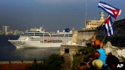 Warga melambaikan bendera-bendera Kuba untuk menyambut penumpang kapal wisata Adonia yang tiba dari Miami di Havana, Kuba, 2 Mei 2016. Pemerintah AS memperketat aturan kunjungan ke Kuba bagi pengunjung Amerika, Rabu, 8 November 2017