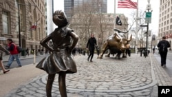 A statue titled "Fearless Girl" faces the Wall Street bull in New York, March 8, 2017. 