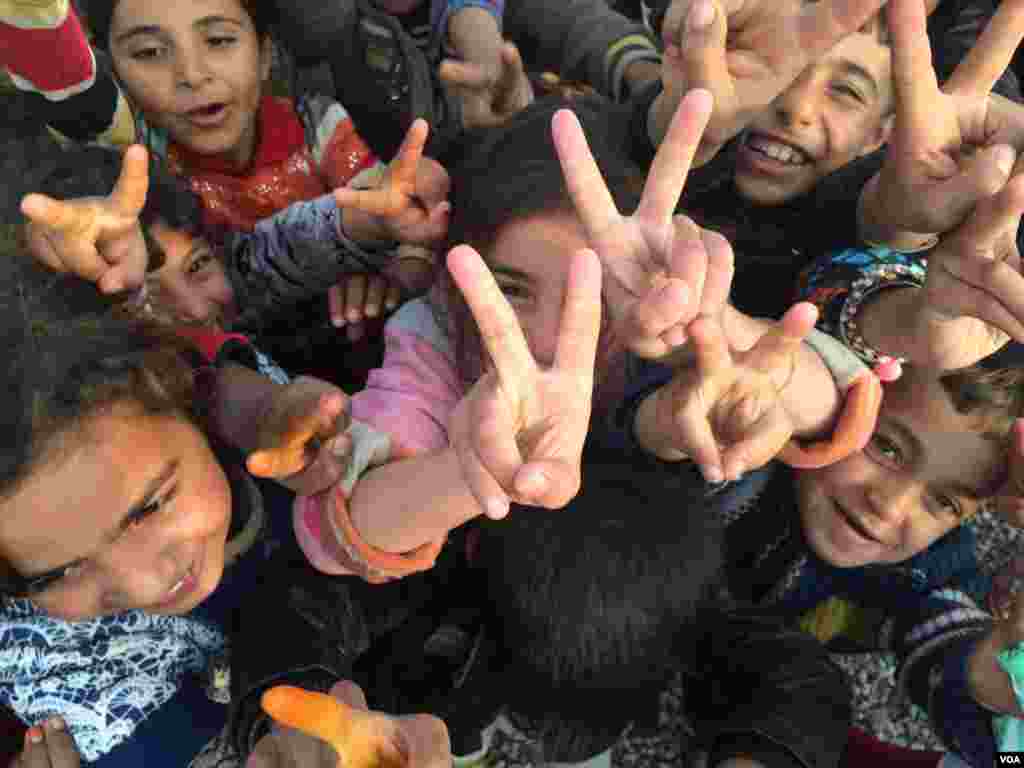 Children all over the region re-captured by the Iraqi Army flash victory signs, saying they have been freed of Islamic State militants. Khazir Camp, Kurdish Iraq on Dec. 1, 2016. (H.Murdock/VOA)