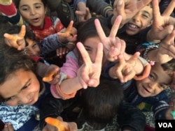 Children all over the region re-captured by the Iraqi Army flash victory signs, saying they have been freed of Islamic State militants. Khazir Camp, Kurdish Iraq on Dec. 1, 2016. (H.Murdock/VOA)