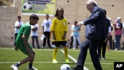 FILE: FIFA President Sepp Blatter kicks a ball during the inauguration of a football stadium in the village of Dura Al-Qari' near the West Bank city of Ramallah, May 20, 2015.