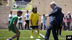 FILE - FIFA President Sepp Blatter kicks a ball during the inauguration of a football stadium in the village of Dura Al-Qari' near the West Bank city of Ramallah, May 20, 2015.
