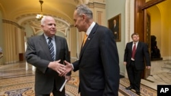 El senador John McCain (izq.) y su par demócrata Charles Schumer, parte del Grupo de los Ocho, celebran la aprobación de una reforma migratoria.
