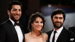 From left, actors Berkay Ates, Tulin Ozen, and director Emin Alper pose during the red carpet for the film Frenzy (Abluka) at the 72nd edition of the Venice Film Festival in Venice, Italy, Sept. 8, 2015. 