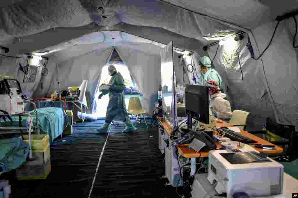 Medical personnel works inside one of the emergency structures that were set up to ease procedures outside the hospital of Brescia, Northern Italy.