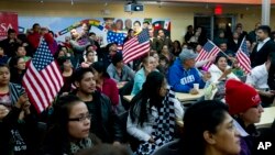 Warga imigran mencermati pidato Presiden Obama yang disiarkan melalui TV mengenai imigrasi di Hyattsville, Maryland (20/11/2014).