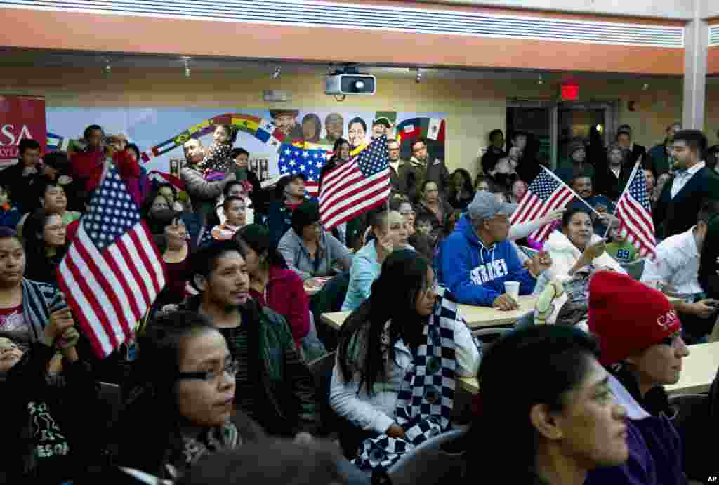 People watch President Barack Obama&#39;s televised immigration speech outlining sweeping changes to the U.S. immigration system that could shield nearly 5 million people here illegally from deportation, without going through Congress, Hyattsville, Maryland, Nov. 20, 2014.