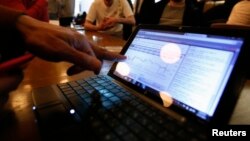 FILE - A man checks the graph showing recent fluctuations on Bitcoin exchange rates against the U.S. dollar on his laptop during a media opportunity at the Tokyo Bitcoin weekly meeting at a restaurant in Tokyo.