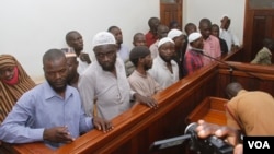 Murder suspects in the killing of Ugandan Police Commander Andrew Felix Kaweesi stand behind the dock at the Nakawa Chief Magistrates court in Kampala, Uganda, May 18, 2017. (H. Athumani/VOA)