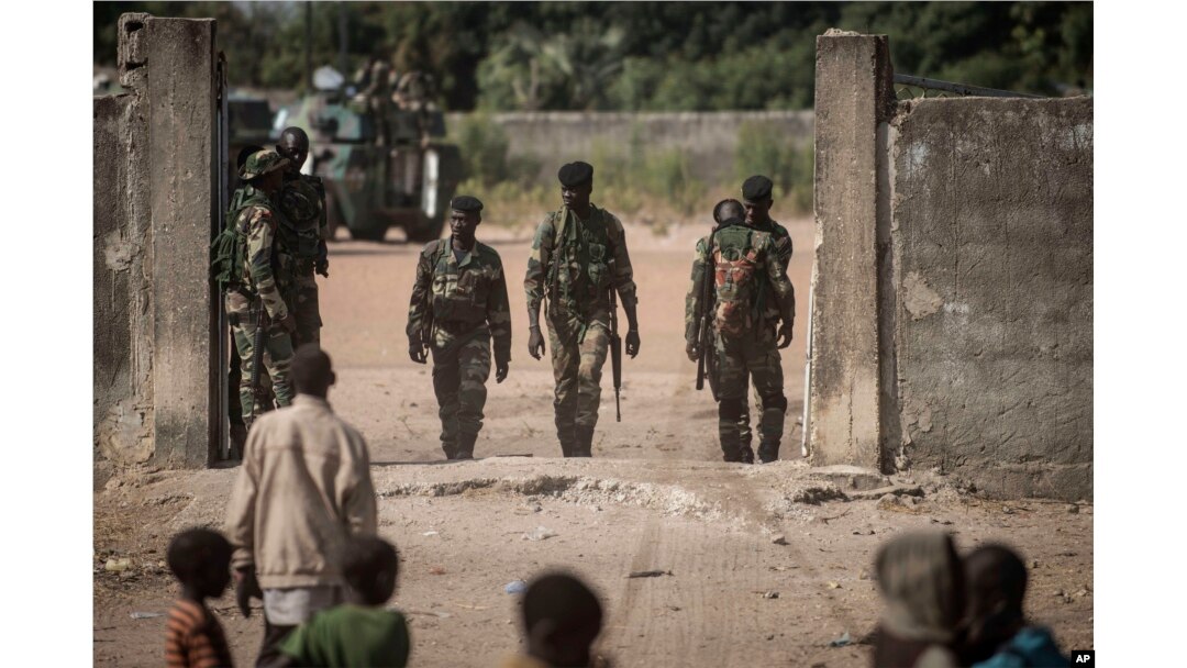 Local children, foreground, look toward Senegal soldiers at the Gambia border with Senegal at the town of Karang, Senegal, Jan. 20, 2017.