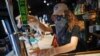 FILE - A bartender pours a beer for a customer at Shade Bar NYC in New York, June 22, 2020. 